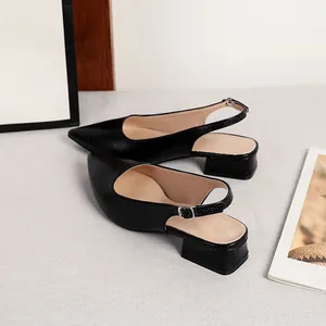 Dettaglio di scarpe slingback nere testurizzate a punta con tacco basso a blocco