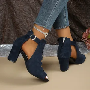 Detailansicht der marineblauen Wildleder-Sandalen mit klobigen Absätzen und Schnalle.