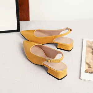 Dettaglio degli escarpin slingback gialli con motivo a serpente e tacco largo basso.