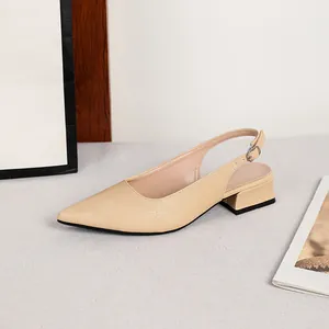 Dettaglio scarpe beige a punta con cinturino posteriore, tacco basso e texture.