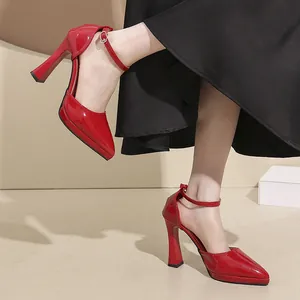 Detailed view of red patent leather pointed-toe pumps with ankle strap and platform