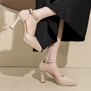 Beige pointed-toe platform pumps with ankle straps worn by a model in a minimalist studio