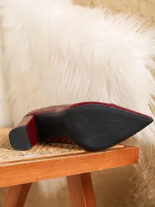 Detail der rutschfesten schwarzen Sohle und des weinroten Blockabsatzes der Damenschuhe