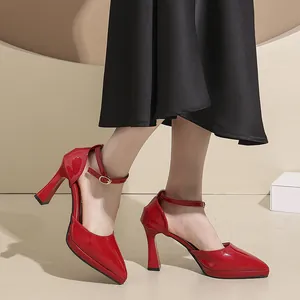 Close-up of red pointed toe platform heels with ankle strap shown on a model