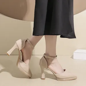 Detailed side view of nude pointed platform high heels with ankle straps worn
