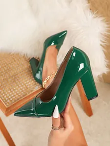 Nahaufnahme eines eleganten grünen Pumps aus Lackleder mit Blockabsatz und spitzer Kappe