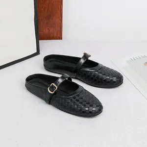 Close-up of black woven texture mule shoes with round toe and gold buckle strap