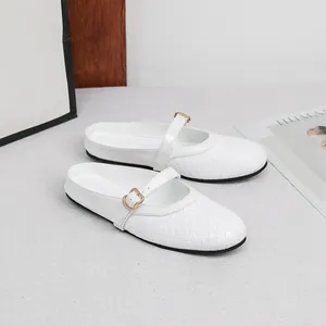 Detailed macro view showing the white woven texture and gold buckle of flat mules.
