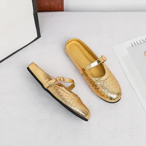 Elegant gold woven flat mules with a round toe and adjustable metallic buckle strap detail.