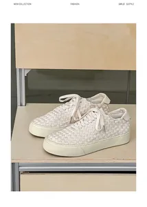 Close-up of beige hand-woven leather sneakers on a minimalist wooden shelf display.