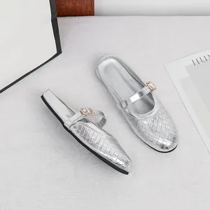Elegant silver round-toe flat mules featuring woven texture and buckle strap details