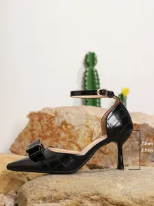 Detail of black crocodile texture high heels with ankle strap and 7.5cm stiletto heel