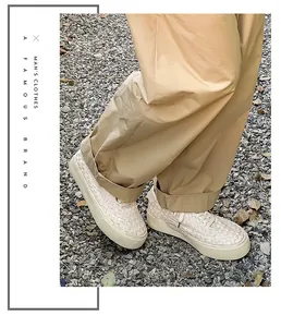 Macro detail view of men's handmade woven low-top casual sneakers on gravel path