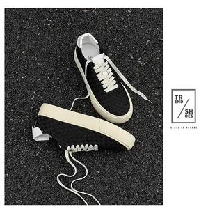 Detailed view of handmade black woven low-top sneakers with durable cream soles