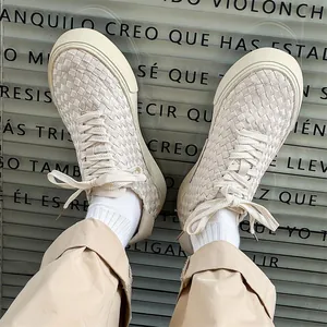 Hand-woven low-top beige casual sneakers for men styled with khaki pants and urban decor