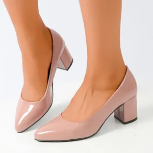 Close-up of elegant nude patent leather pointed toe pumps with sturdy block heels for women
