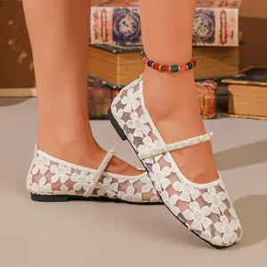 Primer plano detallado de bailarinas de encaje blanco con elegante tira de perlas.