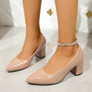Close-up of elegant nude patent leather pointed toe block heel pumps for women