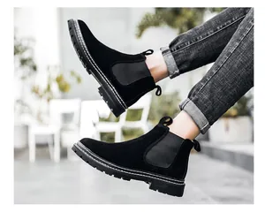 Detailansicht schwarzer Chelsea-Boots aus Wildleder für Herren mit grauer Jeans im Garten