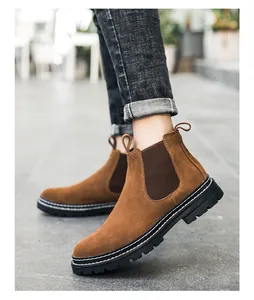 Braune Herren Chelsea-Boots aus Wildleder mit schwarzer Sohle in einer Straßenszene