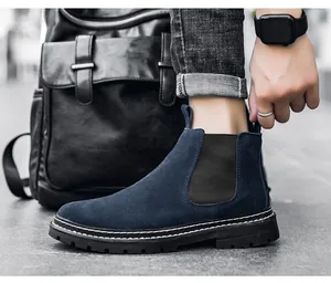 Detailansicht eines blauen Chelsea-Boots aus Wildleder mit Kontrastnähten zu Jeans