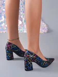Detalle de elegantes salones de tacón ancho con motivos geométricos colorados sobre purpurina.