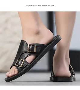Close-up of stylish men's black leather slides with double bronze buckles for summer wear.