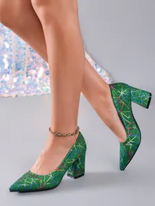 Detalle de elegantes zapatos de salón con purpurina verde, tacón ancho y diseños geométricos