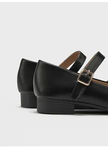 Primer plano de zapato Mary Jane negro con tacón bajo ancho y hebilla dorada detalle