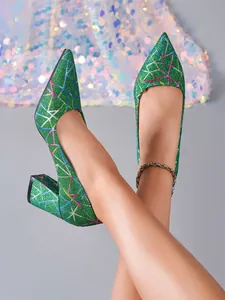 Primer plano de zapatos de tacón bloque con purpurina verde y bordado geométrico