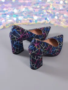 Vista detallada de los zapatos de tacón azul marino con motivos geométricos