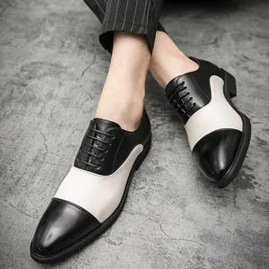Dettaglio ravvicinato di eleganti scarpe Oxford bicolore bianche e nere da uomo.