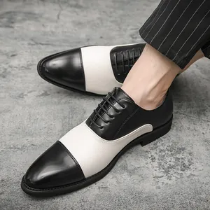 Scarpe da uomo stile britannico in pelle bianca e nera indossate con pantaloni gessati