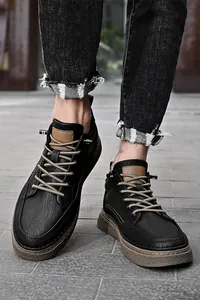 Detailansicht der schwarzen Herren-Freizeitschuhe aus Leder mit Distressed-Jeans