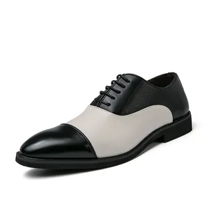 Vista laterale di scarpe stringate Oxford da uomo in pelle bicolore bianco e nero traforata