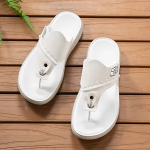Hochwertige Detailansicht von stilvollen weißen Herren-Flip-Flops auf einem Holzdeck