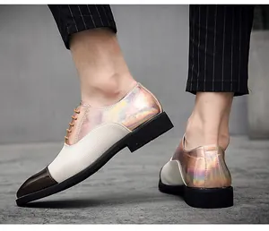Dettaglio delle scarpe in pelle olografica da uomo con i pantaloni gessati neri.