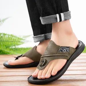 Nahaufnahme der trendigen armeegrünen Flip-Flops für Herren auf einem Holzdeck