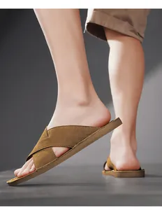 Detailopname van bruine suède herensandalen met kruisbanden voor casual gebruik buitenshuis