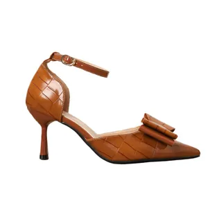 Elegant brown pointed-toe high heels featuring an ankle strap and bow detail.