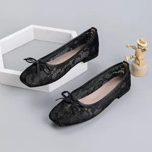 Close-up of black mesh lace ballet flats with elegant bow and square toe detail