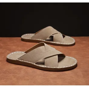 Macro-opname van bruine suède herenslippers met opvallende witte stiksels op de zool