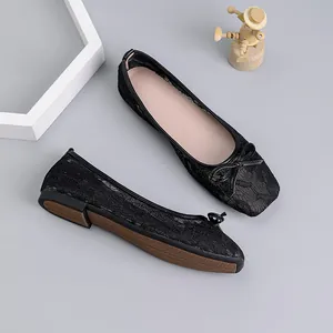 Elegant black lace mesh ballet flats with square toe and bow detail decoration on gray surface