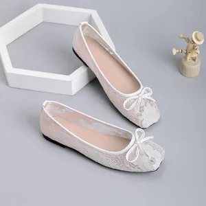 Close-up of delicate lace mesh ballet flats with square toe and bow detail