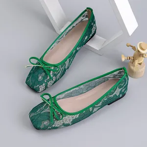 Close-up of elegant green lace hollow ballet flats with square toe and delicate bow detail