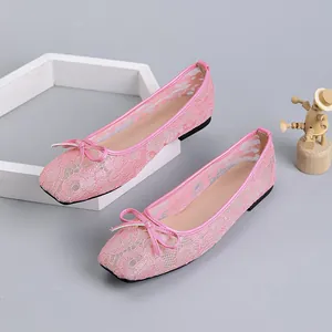 Close-up detail of stylish pink lace mesh ballet flats featuring a bow and square toe