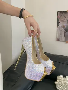 Detail view of white sequin peep-toe pumps with metallic gold platform and high stiletto heel.