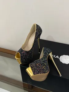 Close-up detail of sexy glitter peep-toe platform pumps with metallic gold stiletto heels.