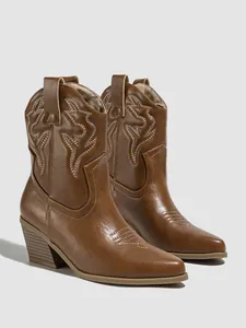 Detailed view of brown embroidered cowboy boots with high heels and pointed toe