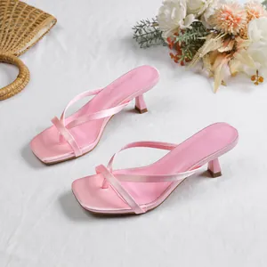Chic pink thong sandals featuring a square toe and slim kitten heel on a white surface